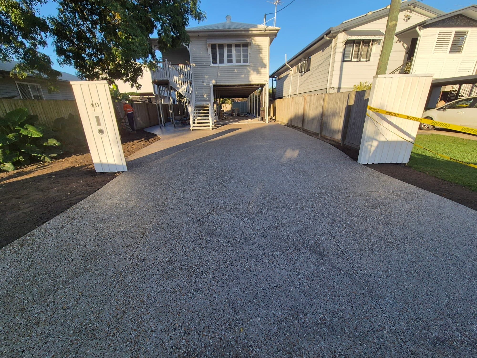Concrete path meeting an exposed-aggregate driveway near a letterbox